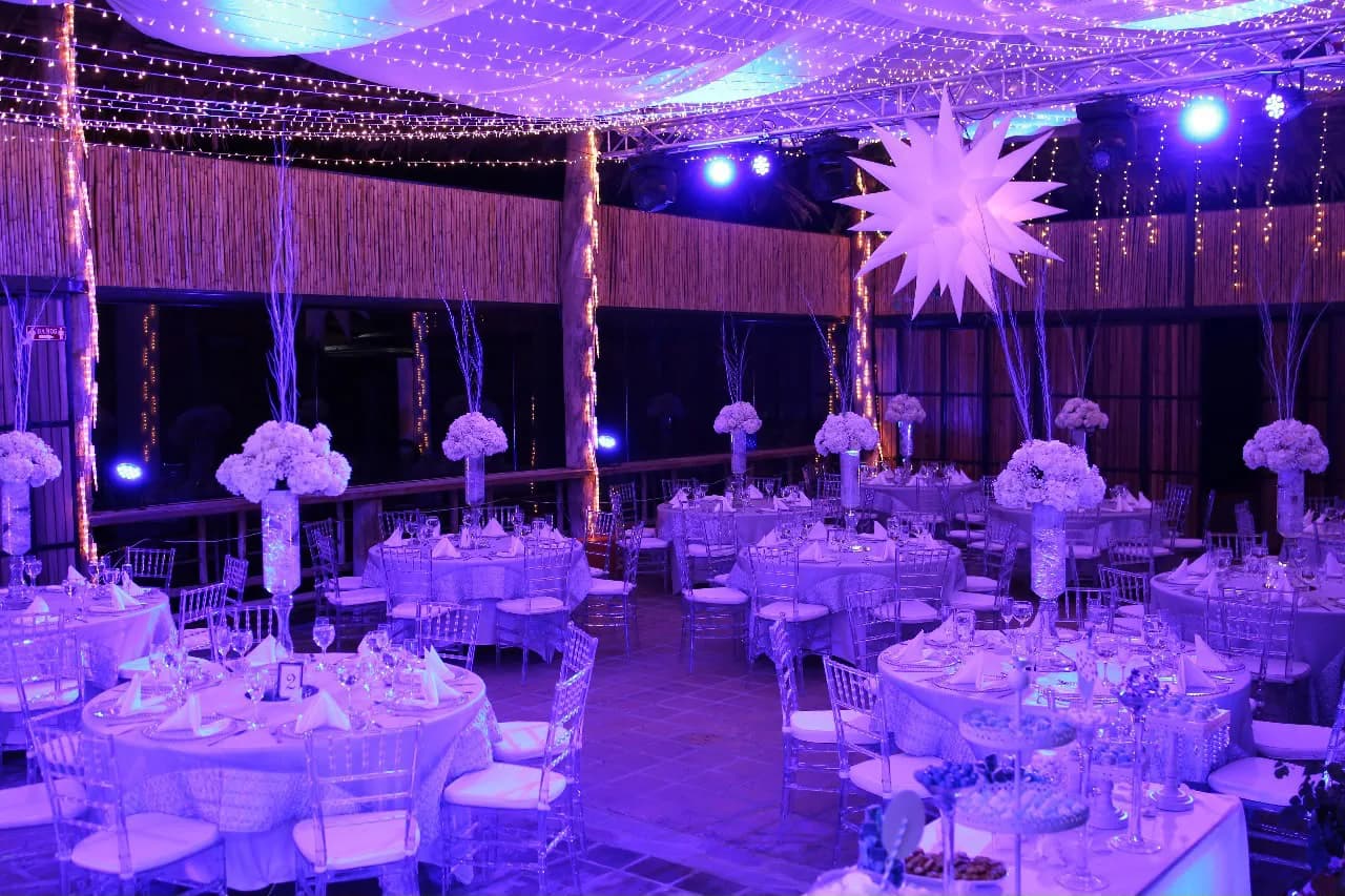 Salón de eventos de Mawá decorado de noche con luces y mesas